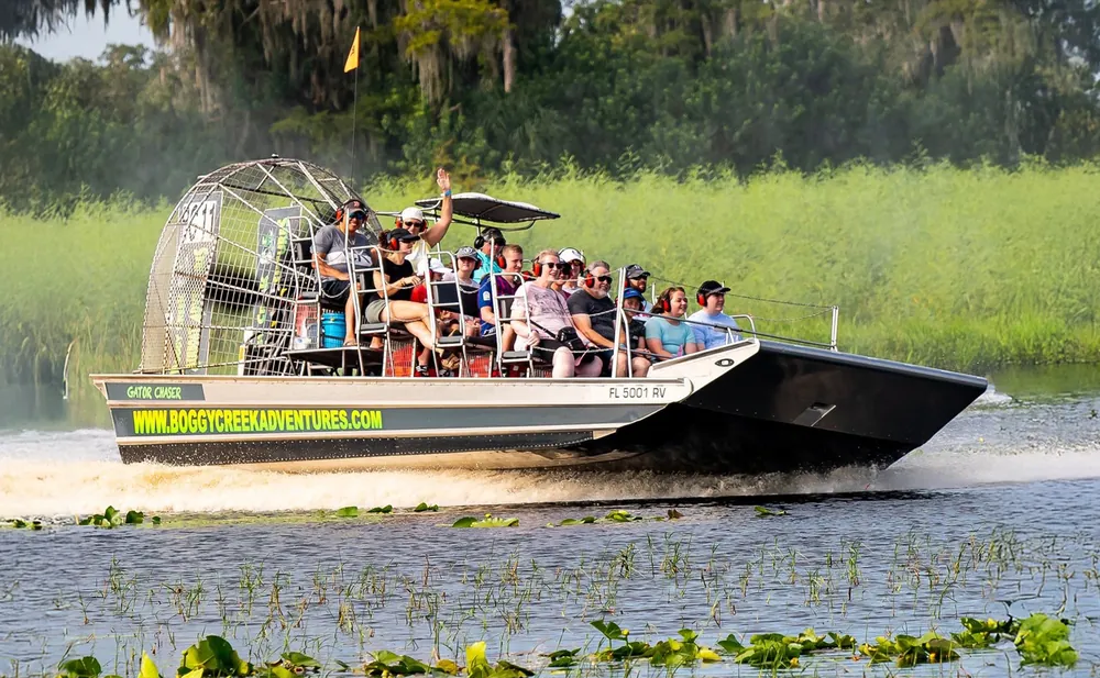 Airboat full of guests gliding through the headwaters of the Everglades